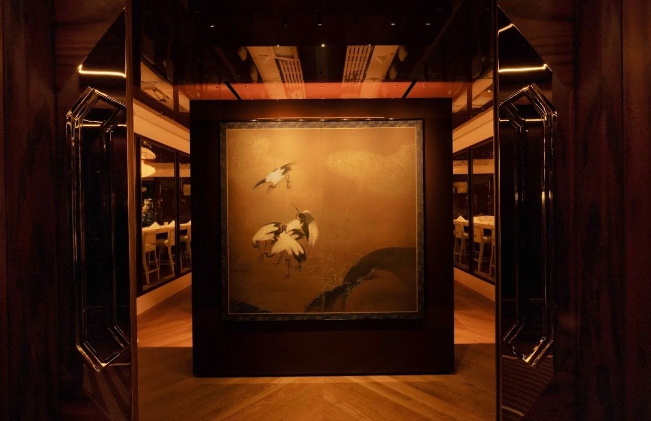 Entrance to Yūgin featuring a golden Japanese screen painting framed by dark wood and soft lighting.