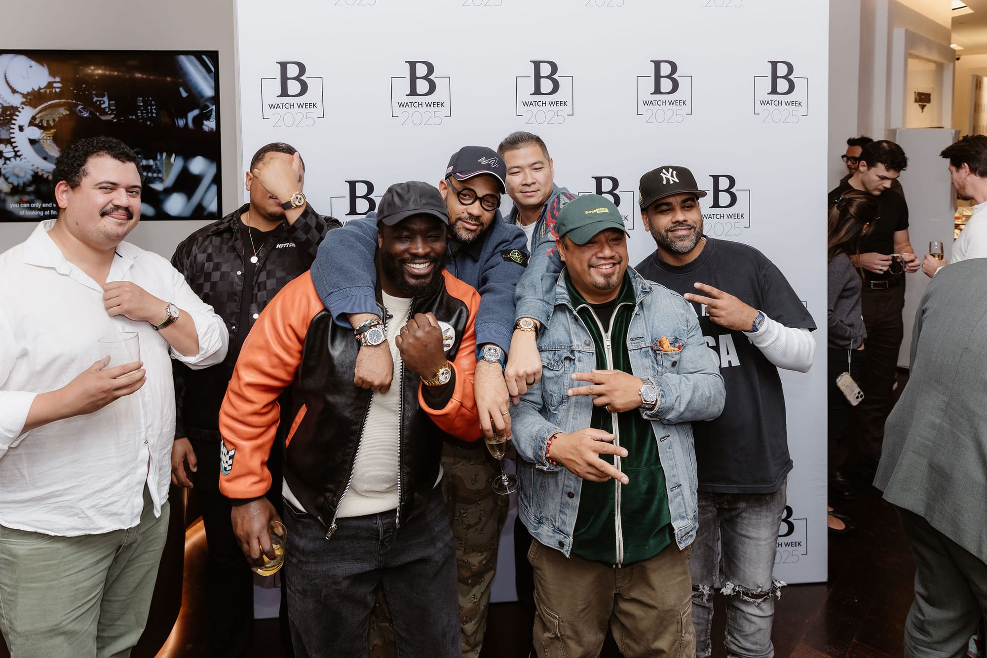Perri Dash, Rashawn Smith, and friends posing at the Super Niche x Bezel event during New York Watch Week in front of a branded backdrop.
