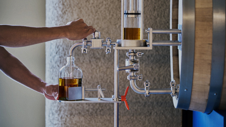 Whisky being drawn through a glass cylinder system at Shindo Distillery, highlighting a hands-on, process-focused approach.
