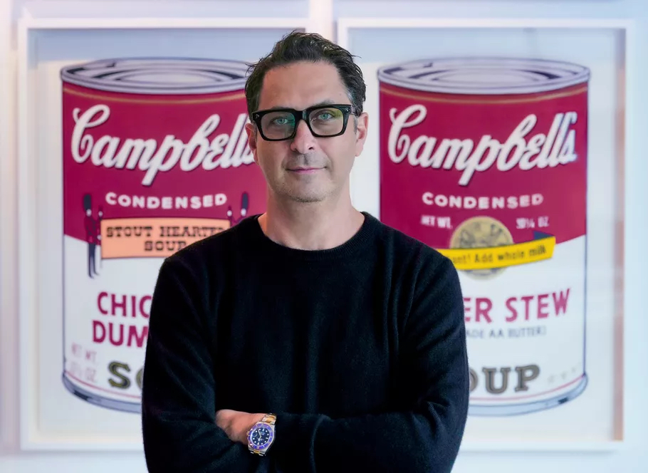 Ron Rivlin, founder and director of Revolver Gallery standing in front of an art